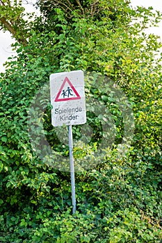 A warning sign with the german text children playing