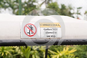 Warning sign on golf cart . Caddies Only.