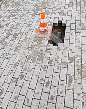 Warning sign and a hole on the sidewalk