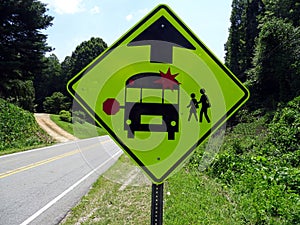 A warning sign indicating the imminent school bus stop and beware of children crossing