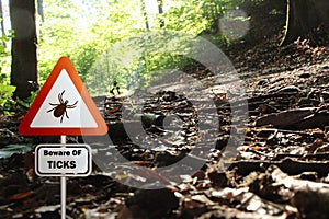 Warning sign for infected ticks in a forest. Risk of tick and Lyme disease.