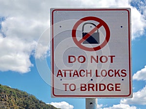 A warning sign informing people not to attach padlocks to a road bridge