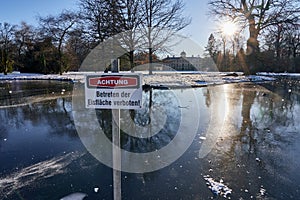 Frozen pond with warning sign