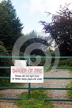 Warning sign on metal gate in woodland