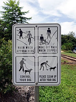 A warning sign with multiple messages for cyclist and dogs