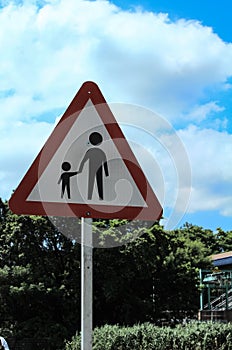 A warning sign of pedestrian on or crossing road ahead.