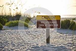 Warning sign poster on sea side beach saying that there is no lifeguard on duty