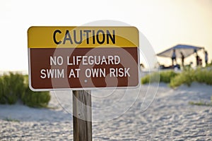 Warning sign poster on sea side beach saying that there is no lifeguard on duty