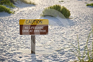 Warning sign poster on sea side beach saying that there is no lifeguard on duty