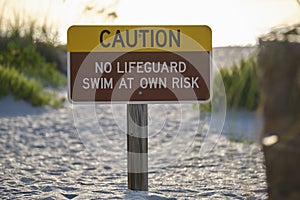 Warning sign poster on sea side beach saying that there is no lifeguard on duty