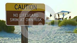 Warning sign poster on sea side beach saying that there is no lifeguard on duty