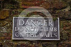 Warning sign reading Danger do not climb on the walls