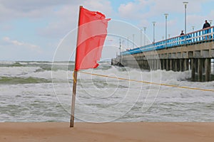 Warning sign of a red flag at a beautiful beach. Swimming are forbidden
