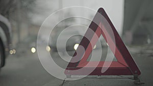 Warning sign `Red Triangle` on the road. Close-up. Crash. Car breakdown