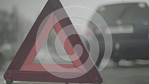 Warning sign `Red Triangle` on the road. Close-up. Crash. Car breakdown