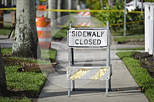 Warning sign that sidewalk is closed at street construction site. Utility work ahead