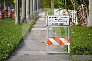 Warning sign that sidewalk is closed at street construction site. Utility work ahead