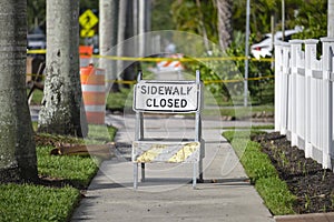 Warning sign that sidewalk is closed at street construction site. Utility work ahead