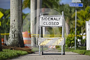 Warning sign that sidewalk is closed at street construction site. Utility work ahead