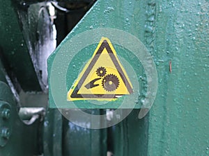 warning sign sticked on a green painted part of a bridge