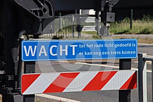 Warning sign to wait untill red light is off at rail road crossing at Waddinxveen for R-NET train