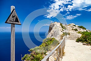 Warning sign at vantage point with view Mirador Es Colomer on punta nau at cap formentor majorca mallorca. Balearic islands