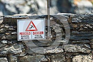Warning sign of fall hazard in English and Italian - Vernazza Italy photo