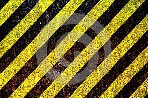 Warning sign yellow and black stripes painted over rusty metal plate as texture background.