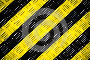 Warning sign yellow and black stripes background painted steel checker plate diamond plate on the floor as texture background