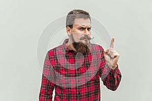Warning sign. Young adult businessman with beard and handlebar m