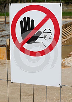 Warning signage prohibiting access with hand to construction site area photo