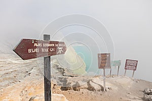 Warning signboard at wastelands in Kawah Ijen volcano crater at sulfur mine