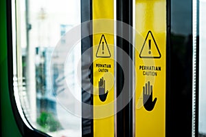 Warning Signs with Hands Symbol on Doors of Indonesia Commuter Train