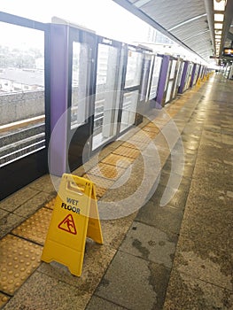 The warning signs wet floor on the sky train station to remind people to walk safely