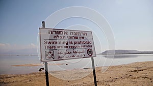 Warning, swimming is prohibited, there are no rescue service, risk of drowning. Sign at hebrew and arabic language
