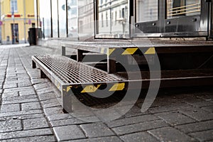 Warning tape on metal stairs outdoors by sidewalk