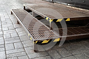 Warning tape on metal stairs outdoors by sidewalk