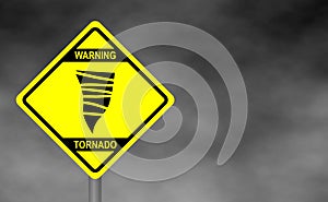 Warning tornado road sign . Yellow hazard warning sign against grey sky -