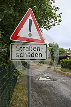 Warning traffic sign with the German text `StraÃŸenschÃ¤den`