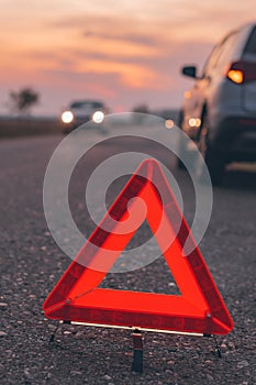 Warning triangle sign on the road in sunset
