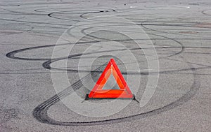 Warning triangle and tire tracks on asphalt