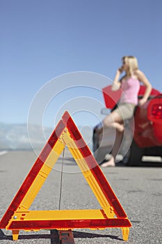 Warning Triangle With Woman On Call By Car On Road