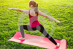 Warrior pose. Practicing yoga in the park