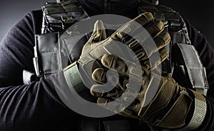 Warrior soldier in tactical gloves standing front view closeup photo