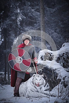 Warrior stands over a growling white tiger