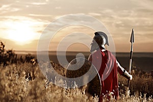 Warrior wearing iron helmet and red cloak.