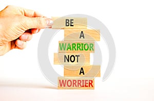 Warrior or worrier symbol. Concept words Be a warrior not a worrier on wooden blocks on a beautiful white table white background.
