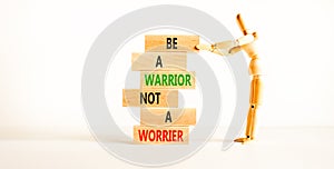 Warrior or worrier symbol. Concept words Be a warrior not a worrier on wooden blocks on a beautiful white table white background.