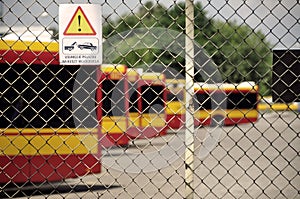 Warsaw city bus depot old rusty fence yellow red buses parked in a row in parking spaces