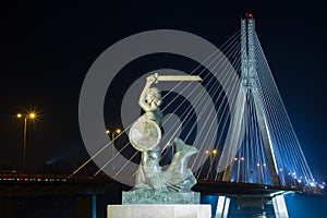 Warsaw by night mermaid on the Vistula river and bridge Swietokrzyski